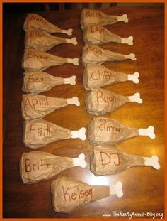 paper mache dogs with names on them sitting on a wooden table in front of an orange frame