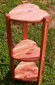 a wooden table sitting on top of a lush green field