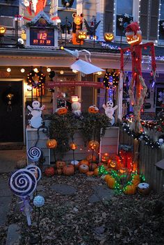 halloween decorations on display in front of a building with lights and pumpkins all around