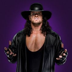 a man with long hair wearing a black hat and leather jacket holding his hands out