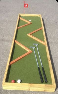 an outdoor miniature golf course with tees and balls on the ground, ready to play