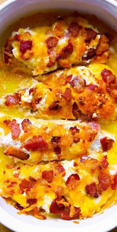 a white bowl filled with cheesy chicken and bacon covered in melted cheese on top