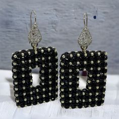 Dramatic black rectangle statement earrings with silver accents.  These beaded earrings are one of a kind, handmade, unique and real  head- turners! Made with high quality Czech facettes and permanent finish silver Japanese seed beads. Permanent finish means they don't tarnish or lose their color. Finished with a silver coloured stainless steel filigree wire earring.  Every item I design is made with the best quality beads, accessories and materials and comes in a handmade embroidered jewellery bag.  Total length: 6,5cm Length drop:  4 cm Width: 3.3 cm Depth:   8 mm Weight (per pair):  22 gr Other colour variations are available in my shop. Black Rectangular Beaded Jewelry, Rectangular Black Beads Jewelry Gift, Rectangular Black Beads Jewelry As Gift, Rectangular Black Beaded Jewelry Gift, Elegant Black Square Jewelry, Unique Black Beaded Dangle Earrings, Unique Black Beaded Earrings, Handmade Dangle Beaded Earrings For Evening, Handmade Black Earrings For Party