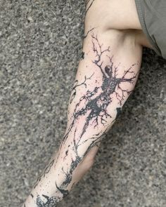 a man's leg with a tree and branches tattoo on his left calf area