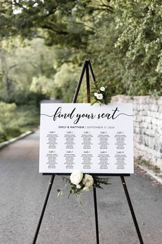 a wedding seating sign with flowers on it