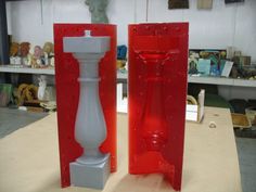 two red and white vases sitting next to each other on top of a table