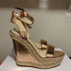 a pair of gold wedges on top of a white counter