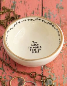 a white bowl sitting on top of a wooden table next to a pair of scissors