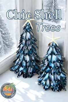 two blue christmas trees sitting in front of a window with the words chic shell trees