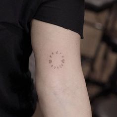 a woman's arm with a small clock tattoo on the left side of her arm