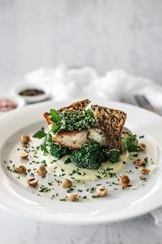 a white plate topped with broccoli covered in sauce