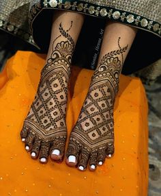 the legs and feet of a woman with henna tattoos