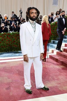 a man with dreadlocks in a white suit