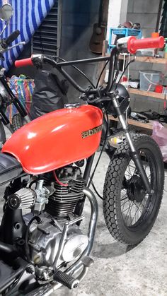 an orange and black motorcycle parked in a garage