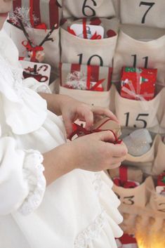 a woman in white dress holding a red and gold gift box with numbers on it