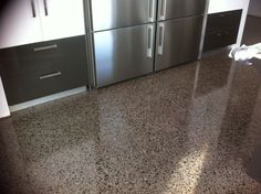 a metallic refrigerator freezer sitting inside of a kitchen