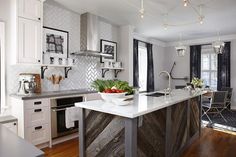 a kitchen with an island, sink and stove in it's center area next to a dining room table