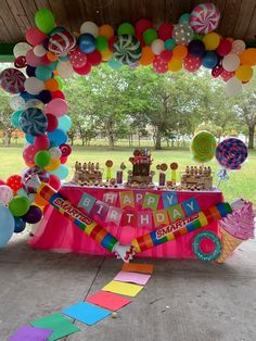 an outdoor birthday party with balloons and cake