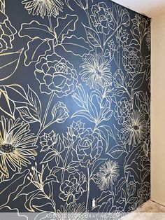 the wall is decorated with flowers and gold foil on blue background, as well as white trim