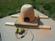 a stone oven sitting on top of a cement slab