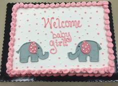 a welcome baby girl cake with two elephants on it