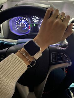 a person wearing an apple watch on their wrist in a car with a steering wheel