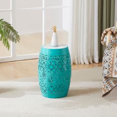 a blue vase sitting on top of a white rug next to a potted plant