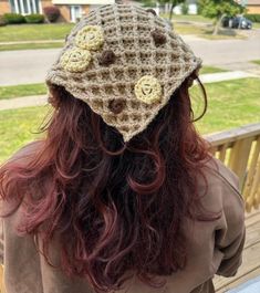 a woman with long hair wearing a crocheted hat on top of her head