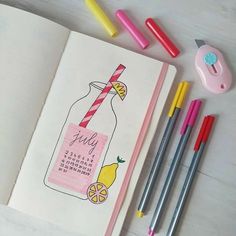 an open notebook with markers and pens next to it