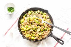 brussel sprouts in a skillet with a spoon on the side