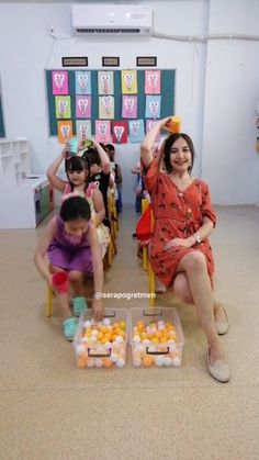 a group of children sitting in front of boxes filled with oranges