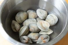 clams in a metal bowl on a wooden table