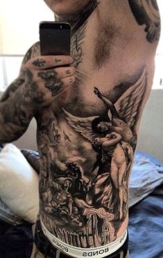 a man with tattoos on his chest holding a cell phone