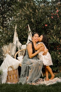 a woman and child sitting on a chair in the grass