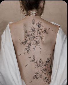 the back of a woman's neck with flowers on it