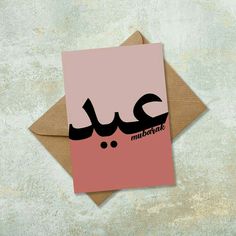 a pink and black greeting card with the word mubarat written in arabic on it