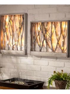 two metal wall art pieces hanging on a brick wall