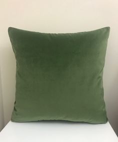 a green pillow sitting on top of a white chair