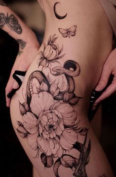 a woman's thigh with flowers and butterflies on it