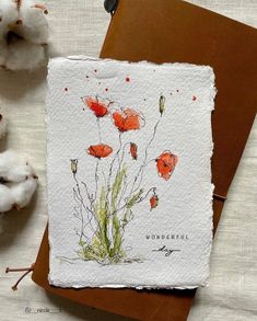 a card with red flowers on it next to some cotton balls and a pair of scissors