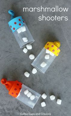 marshmallow shooters in plastic containers with polka dots on the top and one cup filled with candy