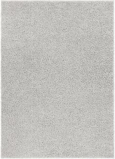 a white rug that is very soft and shaggyly textured with some small dots on it