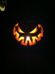 a carved pumpkin is lit up in the dark