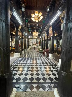 the inside of a building with black and white checkered flooring, chandeliers and mirrors