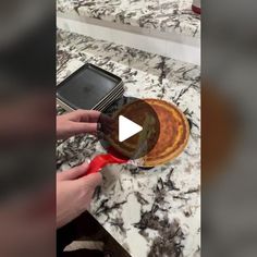 a person using a spatula to mix batter on top of a pan with a red spatula