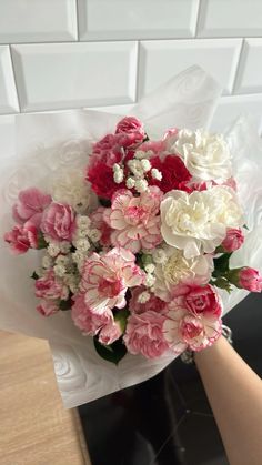 a bouquet of pink and white flowers sitting on top of a table