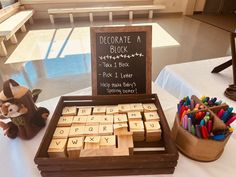 a wooden block set sitting on top of a table next to a sign that says decorate a block