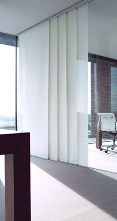 an empty conference room with glass walls and chairs