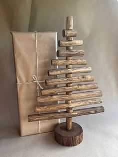 a small wooden christmas tree next to a brown bag