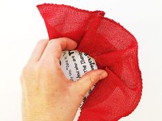 a hand holding a piece of red fabric over a white background with the word, how do you make this?